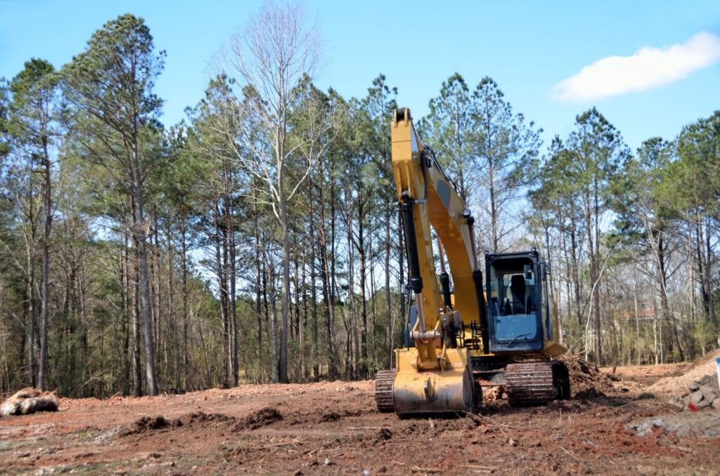 Bulldozer clearing land in pine forest