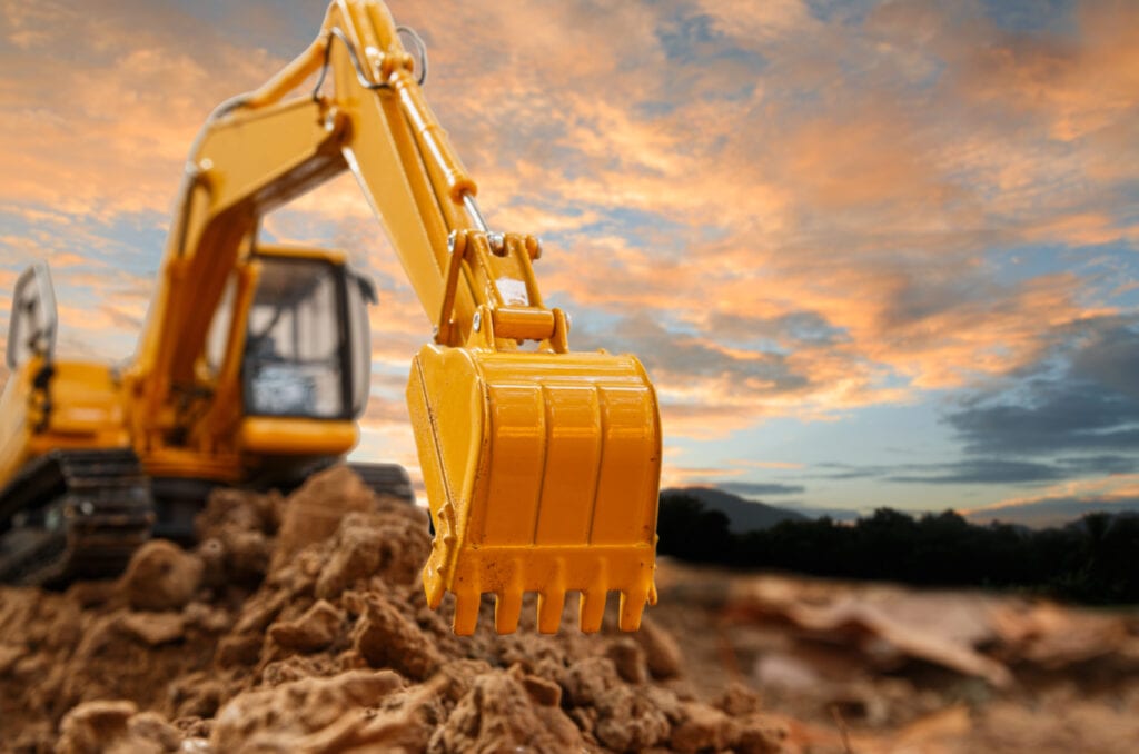 Excavator bucket at sunset on construction site